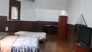 a room with two beds and a flat screen tv at Hospedaje Schell in Lima