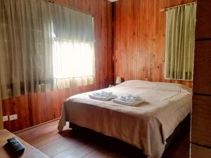 a bedroom with a bed and a window with towels on it at Wesley House in San Martín de los Andes