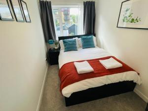 a bedroom with a bed with two pillows and a window at Enfield Chase Apartment in Enfield