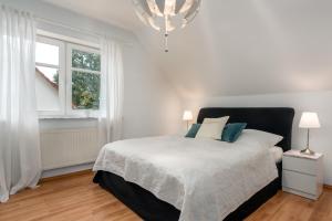 a white bedroom with a bed and a window at Veens Crew Home 7 Pax in Dreieich