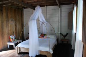 a bedroom with a bed with a canopy at Paraiso Escondido in Bahía Solano