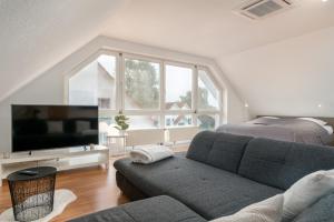 ein Wohnzimmer mit einem Sofa, einem TV und einem Bett in der Unterkunft Veens Crew Home 7 Pax in Dreieich