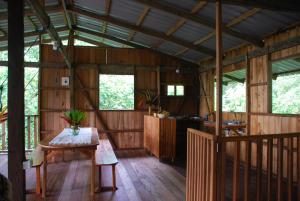 ein Zimmer mit einem Tisch in einem Holzhaus in der Unterkunft Paraiso Escondido in Bahía Solano