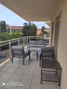 a balcony with chairs and tables on a building at APPART STANDING 2 chambres 2SDB clim PISCINE PARKING WIFI TERRASSE 21m2 LOCAL VELO Port-Aventura, plage, centre in Salou