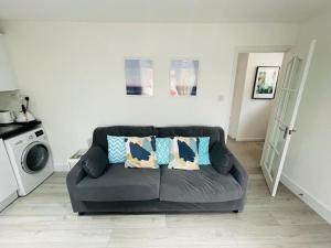 a living room with a couch with pillows on it at Enfield Chase Apartment in Enfield
