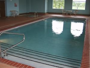 a large swimming pool with two chairs in it at Parkfield Inn - Warsaw in Warsaw
