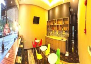 a room with tables and chairs and a yellow wall at Smile Hotel Wangsa Maju in Kuala Lumpur