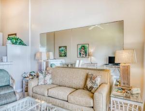 a living room with a couch and a mirror at Mahina Surf - Lahaina, HI by TS in Lahaina
