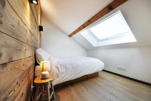 ein Schlafzimmer im Dachgeschoss mit einem Bett und einem Dachfenster in der Unterkunft Superbe appartement, hypercentre au calme avec bain balnéo in Gérardmer