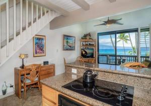 a kitchen with a view of the ocean at Mahina Surf - Lahaina, HI by TS in Lahaina