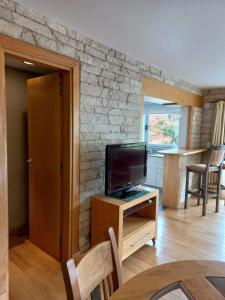 ein Wohnzimmer mit einem Fernseher auf einem Holzschrank in der Unterkunft Departamento Centro San Martin de los Andes in San Martín de los Andes