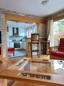 ein Wohnzimmer mit Tisch und Küche in der Unterkunft Departamento Centro San Martin de los Andes in San Martín de los Andes