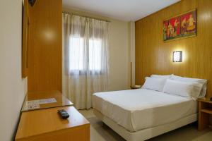 a hotel room with a bed and a window at Hostal Acueducto Los Milagros in Mérida