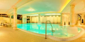 a large swimming pool in a large building at Hotel Almhof in Riezlern