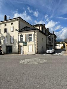 a building with a car parked in a parking lot at Casa de poble acollidora,amb llar de foc, in Bourg-Madame