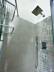 a bathroom with a shower with a tile wall at La Rocca Luxury Apartment in Parma