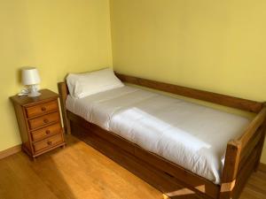 a small bedroom with a bed and a night stand at Casa de poble acollidora,amb llar de foc, in Bourg-Madame +5 photos