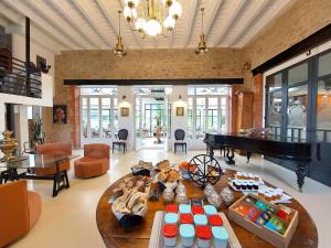 a living room with a piano and a table at Laiterie de Tocqueville B&B in Tocqueville