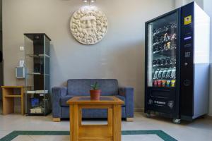 a living room with a couch and a drink refrigerator at Hostal Acueducto Los Milagros in Merida