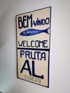 um sinal pendurado numa parede com um peixe em Charming Portuguese style apartment, for rent "Vida à Portuguesa", "Fruta or Polvo" Alojamento Local em Portimão