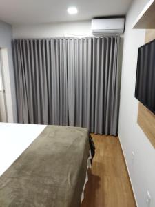 a bedroom with a bed and a television in a room at Chapada Confort Flats in Alto Paraíso de Goiás