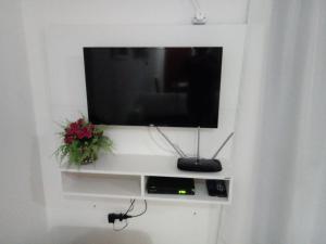 a flat screen tv on a white wall at Apto. 2 quartos em Bombinhas (60 m da praia) in Bombinhas