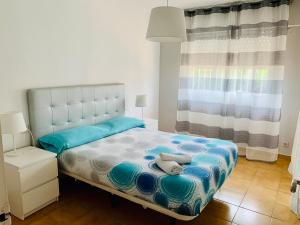 sypialnia z łóżkiem z niebiesko-białą kołdrą w obiekcie Bungalow in San Juan Playa w mieście Benimagrell +33 zdjęcia