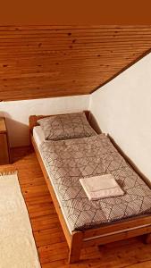 a bed in a room with a wooden ceiling at Apartman Ivano in Gospić