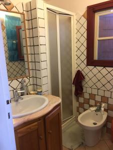 a bathroom with a sink and a shower and a toilet at Villa Vera trifamigliare con ingresso diretto 20 mt al mare clima wi-fi bbq in Cala Liberotto