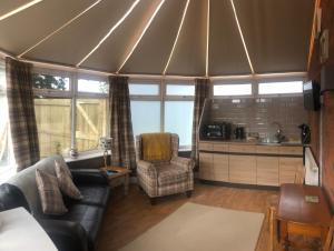 a living room with a couch and chairs in a tent at Nanny Goat Rest At Ashlands Farm in Abbots Bromley