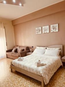 een slaapkamer met een groot bed en een bank bij Stella in Centro in Salerno