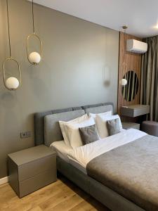 um quarto com uma cama com lençóis brancos e almofadas em Дизайнерские Апартаменты класса Люкс! em Bila Tserkva