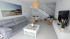 a living room with a couch and a table at VILLA TRAFALGAR, magnífica casa en la costa ideal para familias que buscan tranquilidad in Playa Blanca