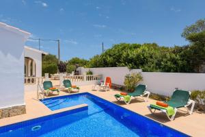 una piscina con tumbonas y una piscina en Villa CLAUDIA Menorca, en Cala'n Porter