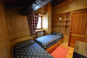 an empty room with two beds in a cabin at Maison de Santino in Cogne