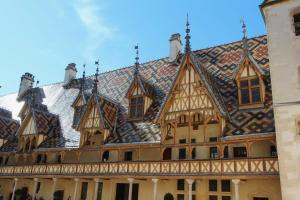 un edificio ornamentado con techo de baldosa en Chez Charles Centre-Parking privé-Hospices-Gare en Beaune