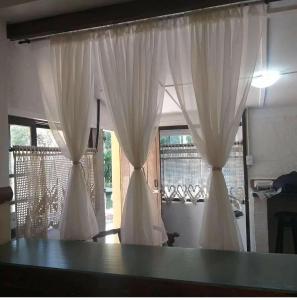 uma mesa com cortinas brancas num quarto em Chalé do lago Ladeira de Pedra em Salesópolis