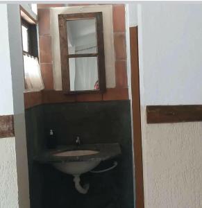 a bathroom with a sink and a mirror at Chalé do lago Ladeira de Pedra in Salesópolis