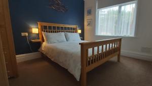 Un dormitorio con una cama grande y una ventana. en Three Beaches Holiday Apartments - close to Goodrington beach in Paignton, en Paignton