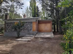 a house with a wooden door and a garage at Casa Elisa in Ciudad Lujan de Cuyo