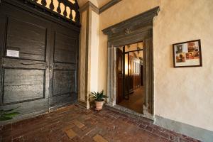 un couloir vide avec une porte et une plante en pot dans l'établissement Contucci Residenze d'Epoca, à Montepulciano