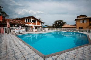 a swimming pool with a woman sitting on a bench next to a house at Ilha Náutica in Florianópolis