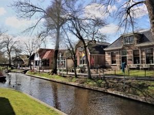 a river with houses and buildings next to a house at Apartment in Giethoorn by Scenic Canals in Giethoorn
