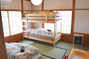 two bunk beds in a room with windows at Myoko House in Myoko