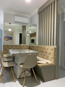 uma cozinha com uma mesa e cadeiras e um sofá em Apartamento aconchegante próximo a tudo em Piratuba Oeste Catarinense em Piratuba