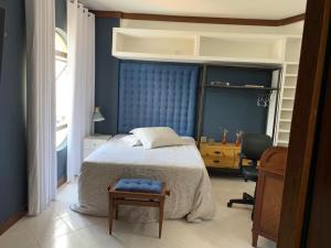 a bedroom with a bed and a desk and a chair at Apartamento confortável, região do Iguatemi in Salvador