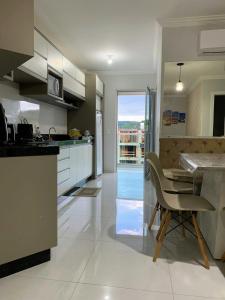 uma cozinha com uma mesa e uma sala de jantar em Apartamento aconchegante próximo a tudo em Piratuba Oeste Catarinense em Piratuba