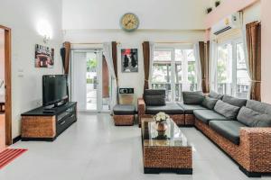 a living room with a couch and a tv at Super garden,Thai style villa, 5BR in Jomtien Beach