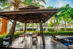 una terraza de madera con sillas y una mesa bajo una pérgola en Super garden,Thai style villa, 5BR en Jomtien Beach