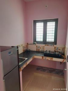 a kitchen with a counter top and a refrigerator at Quality Inn Varkala in Varkala